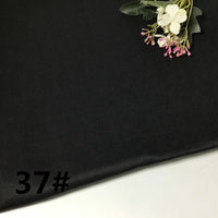 A piece of black, lightweight ramie fabric from Longan Craft’s “Colorful Lightweight Ramie Fabric By The Yard” collection features a small floral arrangement in the top right corner, with the number 37# printed in black at the lower left.