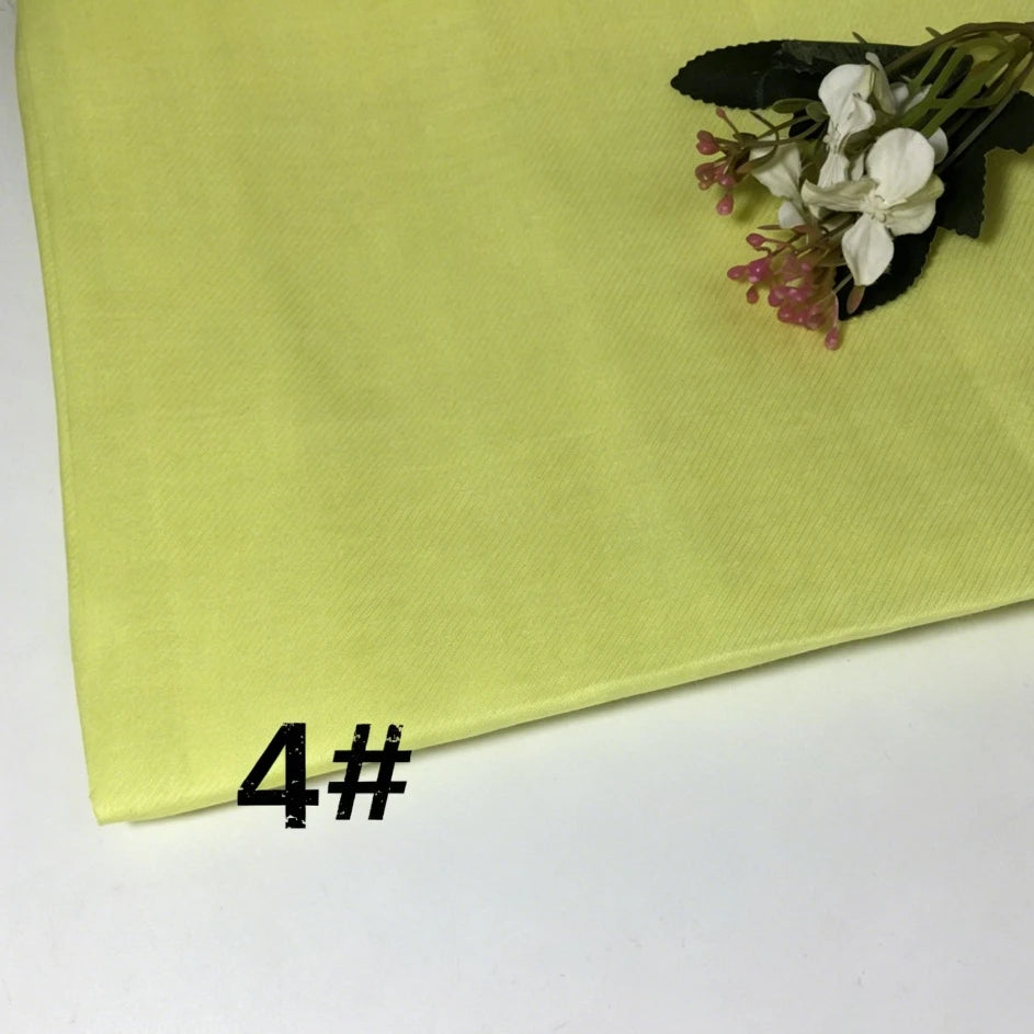 A folded piece of light yellow Colorful Lightweight Ramie Fabric By The Yard from Longan Craft rests on a white surface. A small flower arrangement decorates the upper right corner, while the number 4# is printed in black on the lower left.