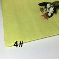 A folded piece of light yellow Colorful Lightweight Ramie Fabric By The Yard from Longan Craft rests on a white surface. A small flower arrangement decorates the upper right corner, while the number 4# is printed in black on the lower left.