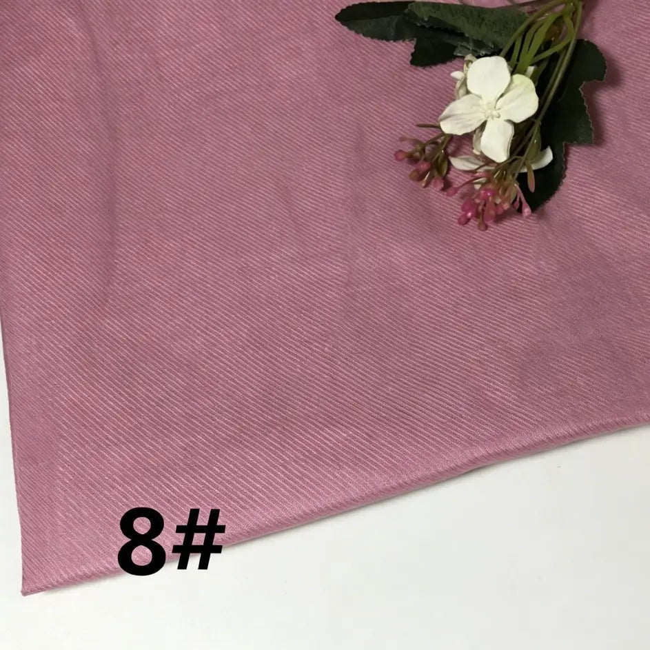 A piece of Longan Craft’s Colorful Lightweight Ramie Fabric in a pink solid color is displayed, featuring its soft and textured appearance. A small bouquet of artificial flowers rests on top, while the number 8# appears prominently in bold black text at the lower left corner.