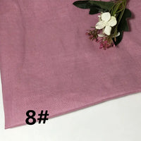 A piece of Longan Craft’s Colorful Lightweight Ramie Fabric in a pink solid color is displayed, featuring its soft and textured appearance. A small bouquet of artificial flowers rests on top, while the number 8# appears prominently in bold black text at the lower left corner.