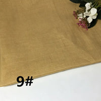 A piece of light brown Colorful Lightweight Ramie Fabric By The Yard from Longan Craft is displayed, with artificial flowers in the top right corner. Known for its breathable qualities, this solid color pure ramie material is both stylish and practical for garment making. The number 9# appears in black on the bottom left.