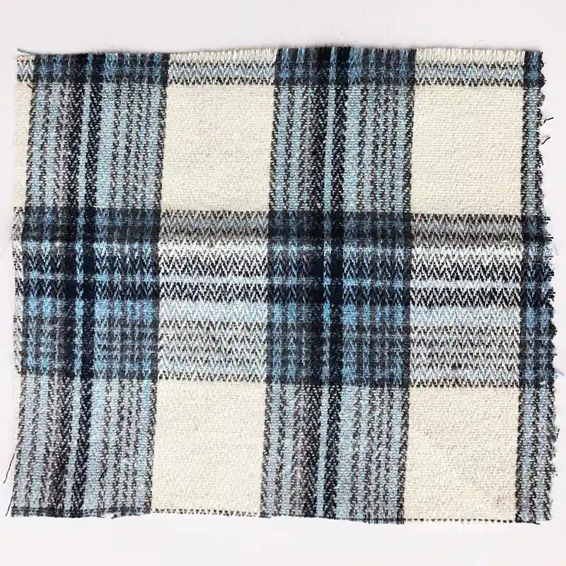 A square swatch of Longan Craft’s Colorful One Side Sueded Flannel Fabric By The Yard showcases a yarn-dyed cotton plaid in black, blue, gray, and white tones. The unfinished edges and visible weave highlight the textured appearance of this soft Super Snuggle Fall flannel material.