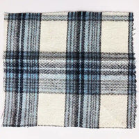 A square swatch of Longan Craft’s Colorful One Side Sueded Flannel Fabric By The Yard showcases a yarn-dyed cotton plaid in black, blue, gray, and white tones. The unfinished edges and visible weave highlight the textured appearance of this soft Super Snuggle Fall flannel material.