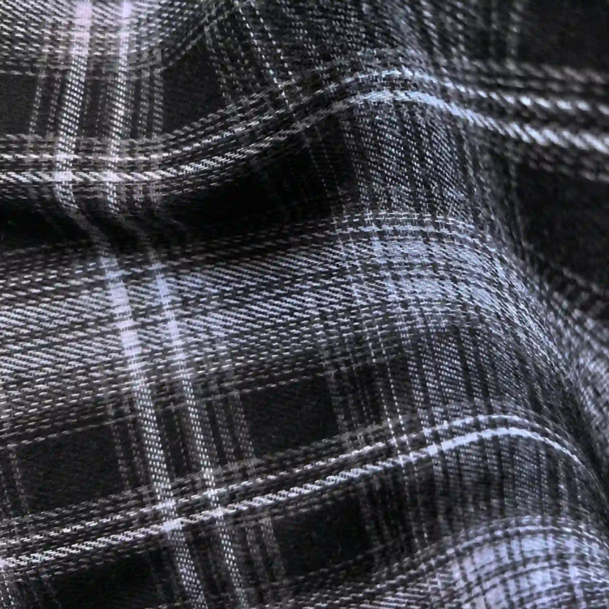 Close-up of Longan Craft’s Colorful One Side Sueded Flannel Fabric by the yard, a yarn-dyed cotton plaid flannel with intersecting lines and a super snuggle soft texture, featuring black and white checks with a slightly wrinkled finish.