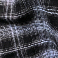 Close-up of Longan Craft’s Colorful One Side Sueded Flannel Fabric by the yard, a yarn-dyed cotton plaid flannel with intersecting lines and a super snuggle soft texture, featuring black and white checks with a slightly wrinkled finish.