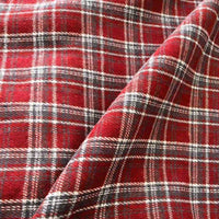 Colorful One Side Sueded Flannel Fabric By The Yard from Longan Craft features a yarn-dyed cotton plaid design with white, black, and yellow lines on a red background forming a classic checkered pattern. Slight folds highlight this Super Snuggle Fall Flannel Material’s soft texture, brushed sueded finish, and substantial thickness.