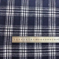 A metal ruler placed on Longan Craft’s Colorful One Side Sueded Flannel Fabric By The Yard—a yarn dyed cotton plaid flannel—shows a close-up of the blue and white pattern and scale in centimeters.