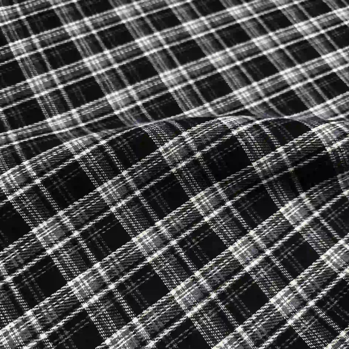 Close-up of the Longan Craft Colorful One Side Sueded Flannel Fabric By The Yard—yarn dyed cotton plaid with intersecting black and white lines forming a checkered pattern—showing the soft, super snuggle material with a gentle wave or fold.