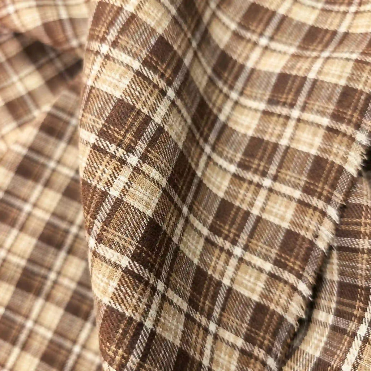 Close-up of Longan Craft’s Colorful One Side Sueded Flannel Fabric By The Yard, a super snuggle fall material made from yarn dyed cotton with a brown and beige plaid pattern, featuring a soft sueded texture and visible weave detail.