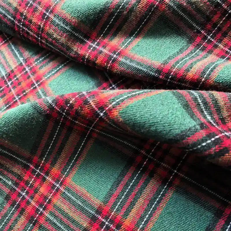 Close-up of Longan Craft’s Colorful One Side Sueded Flannel Fabric By The Yard, a yarn-dyed cotton plaid flannel with a green, red, and black tartan pattern, highlighting its super snuggle texture and soft folds.