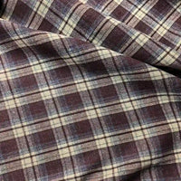 A close-up of the Longan Craft Colorful One Side Sueded Flannel Fabric by the yard showcases its purple and beige yarn dyed cotton plaid design, with intersecting lines forming a classic checkered pattern. The super snuggle fall flannel material appears soft and slightly wrinkled, emphasizing its cozy, sueded texture.