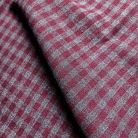 Close-up of Longan Craft’s Colorful One Side Sueded Flannel Fabric By The Yard, a yarn dyed cotton plaid featuring a red and gray checkered pattern with visible texture and folds. The super snuggle fall flannel material displays small squares arranged in a regular grid.