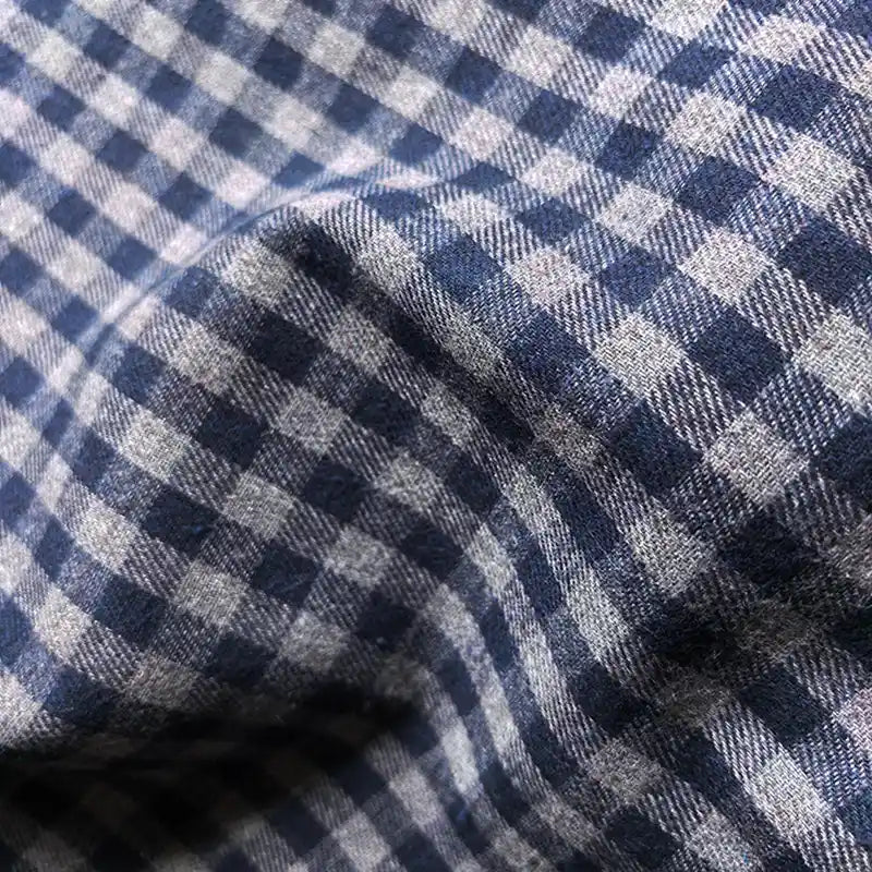 Close-up of Longan Craft’s Colorful One Side Sueded Flannel Fabric By The Yard, a yarn dyed cotton plaid flannel with a blue and white checkered pattern. The brushed surface is textured and slightly wrinkled, forming a grid of small squares characteristic of Super Snuggle Fall Flannel Material.