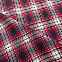 Close-up of the Longan Craft Colorful One Side Sueded Flannel Fabric By The Yard, a yarn dyed cotton plaid material, in shades of red, white, and black. The image features a diagonal fold that showcases the soft sueded texture and detailed woven pattern of this Super Snuggle Fall Flannel.