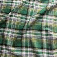 Introducing the Longan Craft Colorful One Side Sueded Flannel Fabric By The Yard: a super snuggly, yarn-dyed cotton plaid flannel material featuring green, yellow, white, and black crisscrossed lines forming intersecting squares in various shades, all with a softly brushed texture and slightly wrinkled finish—perfect for fall projects.