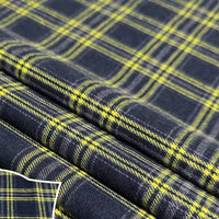 A folded piece of Longan Craft Colorful One Side Sueded Flannel Fabric By The Yard displays a black and yellow yarn-dyed cotton plaid with intersecting stripes and squares. The inset provides a close-up view, highlighting the soft, brushed flannel texture and detailed plaid design that makes this Super Snuggle Fall Flannel Material perfect for cozy projects.