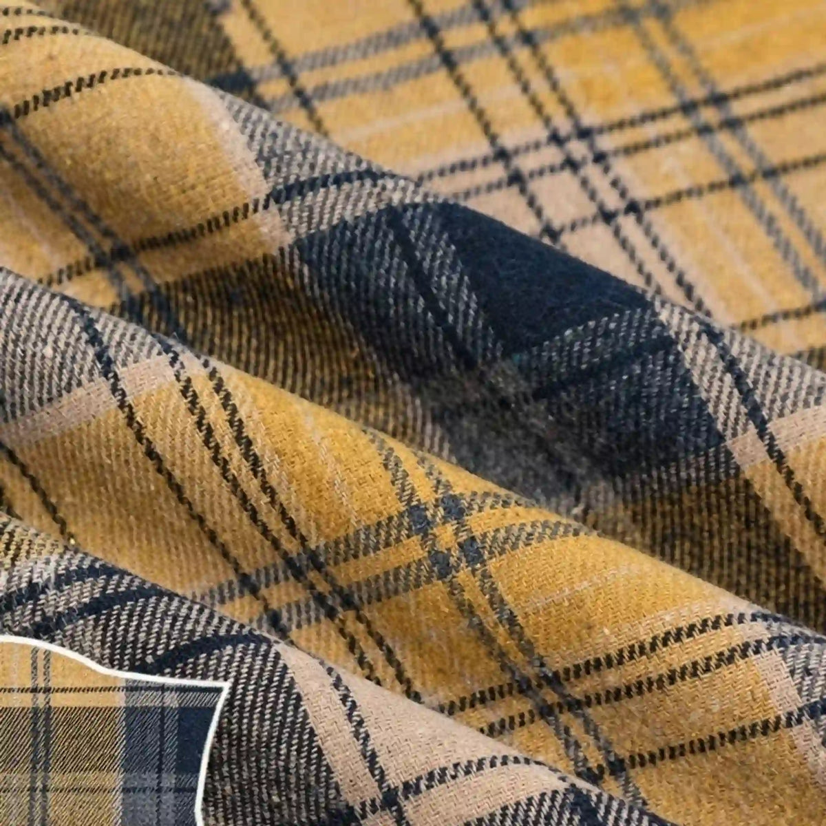 Close-up of Longan Craft’s Colorful One Side Sueded Flannel Fabric By The Yard, a super snuggle fall yarn-dyed cotton plaid featuring intersecting yellow, black, and beige lines in a checkered pattern on a soft, textured flannel surface.