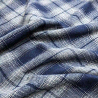 Close-up of Longan Craft Colorful One Side Sueded Flannel Fabric By The Yard, a yarn-dyed cotton plaid flannel featuring intersecting lines and squares in varying blue and white shades. Soft folds highlight the brushed, super snuggle texture of this fall-ready fabric.