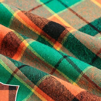 Close-up of folded Colorful One Side Sueded Flannel Fabric By The Yard from Longan Craft, showcasing its vibrant green, orange, black, and yellow plaid pattern and the textured weave of this super snuggle yarn dyed cotton flannel material.
