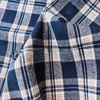 Close-up of the Colorful One Side Sueded Flannel Fabric by Longan Craft, featuring intersecting blue, white, and black yarn-dyed plaid lines and a crumpled texture characteristic of super snuggle cotton flannel material.