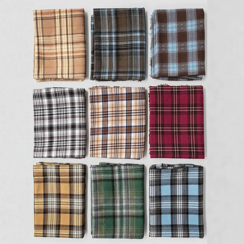 Nine neatly folded swatches of Longan Craft’s Colorful One Side Sueded Flannel Fabric By The Yard are displayed in a 3x3 grid on a white background, each featuring distinct yarn-dyed plaid patterns in shades of brown, blue, red, green, yellow, and black. Crafted from super snuggle cotton flannel material, this fabric showcases the softness and warmth of classic brushed flannel styles.