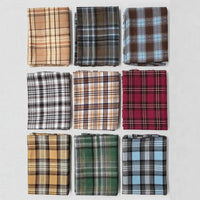 Nine neatly folded swatches of Longan Craft’s Colorful One Side Sueded Flannel Fabric By The Yard are displayed in a 3x3 grid on a white background, each featuring distinct yarn-dyed plaid patterns in shades of brown, blue, red, green, yellow, and black. Crafted from super snuggle cotton flannel material, this fabric showcases the softness and warmth of classic brushed flannel styles.