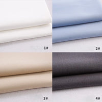 Four stacks of Longan Craft Colorful Rayon Polyester Blend Gabardine Fabric: white (1#, top left), light blue (2#, top right), beige (3#, bottom left), and dark gray (4#, bottom right)—ideal for DIY uniforms.