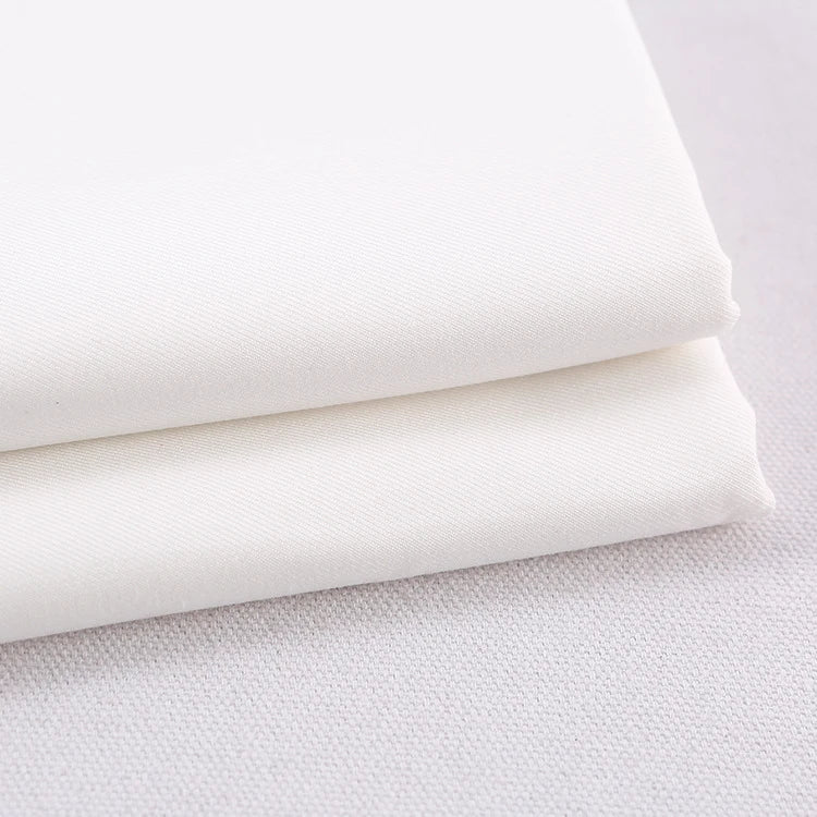 Two pieces of Longan Craft Colorful Rayon Polyester Blend Gabardine Fabric, heavyweight viscose gabardine material perfect for DIY uniforms, are stacked on a white textured surface.