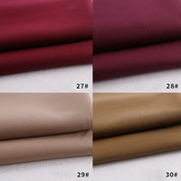 Four Rayon Polyester Blend Gabardine swatches from Longan Craft—deep red (27#), wine red (28#), light beige (29#), and light brown (30#)—are shown folded with numbered labels, perfect for uniforms or DIY projects.