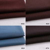 Four swatches of Longan Craft's Colorful Rayon Polyester Blend Gabardine Fabric are shown: dark brown (44#), medium brown (45#), light blue (46#), and very dark brown (47#)—each neatly folded on a white surface.