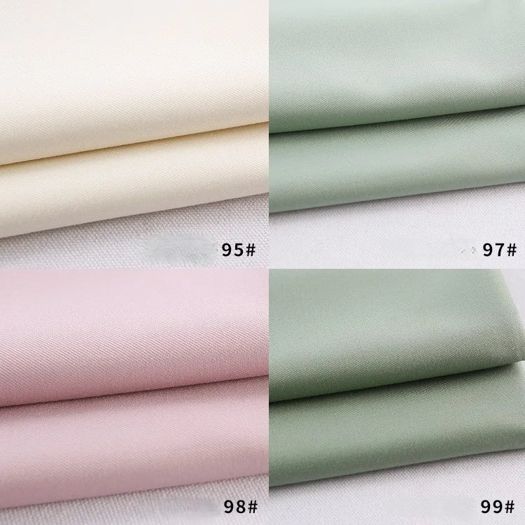 Four stacks of Longan Craft's Colorful Rayon Polyester Blend Gabardine Fabric in off-white (95#), light green (97#), light pink (98#), and sage green (99#)—each section labeled with a number in the bottom right corner.
