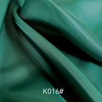 A close-up of Longan Craft’s Colorful Satin Viscose Fabric by the yard shows smooth, green polyester-viscose twill with gentle folds and a soft sheen. The text K016# appears at the image’s bottom center. Ideal for formal dresses.