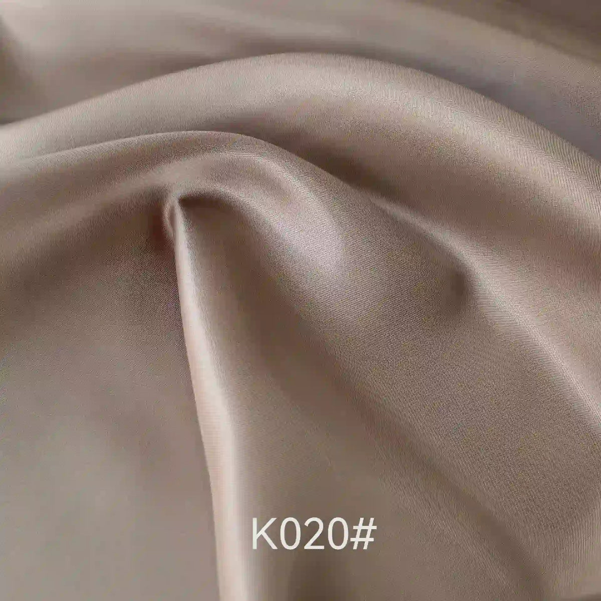 Close-up of elegant, shiny light brown Colorful Satin Viscose Fabric By The Yard from Longan Craft (code "K020#"), featuring a soft, lustrous polyester viscose twill weave with gentle folds—ideal for formal dresses.