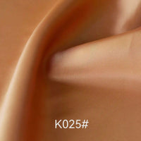 Close-up of smooth, shiny, light brown Colorful Satin Viscose Fabric By The Yard from Longan Craft with gentle folds and a soft texture. The text K025# is displayed at the bottom center of the image.