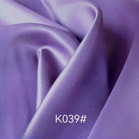Smooth, shiny lavender-colored Colorful Satin Viscose Fabric by the yard from Longan Craft draped in soft folds, featuring a twill weave—perfect for elegant formal dresses.