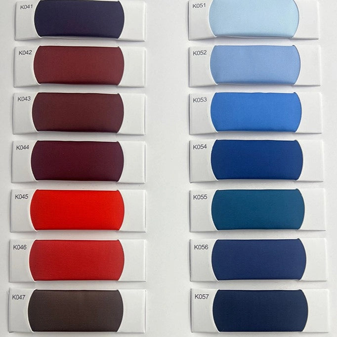 A display of 13 Longan Craft Colorful Satin Viscose fabric swatches (K041–K057), arranged in two columns, shows elegant polyester viscose twill weaves from deep reds and maroons to light blue and navy—ideal for formal dresses.