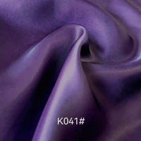 A close-up of smooth, flowing purple Colorful Satin Viscose Fabric by Longan Craft with twill weave, soft folds, and highlights. The text K041# is displayed at the bottom center of the image.