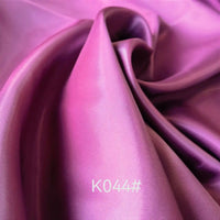 A close-up of Colorful Satin Viscose Fabric By The Yard from Longan Craft, showing smooth purple polyester viscose with a twill weave and soft sheen. “K044#” appears in white text at the bottom of the image.