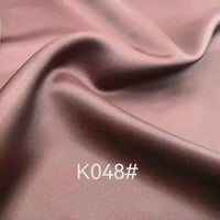 Close-up of smooth, shiny mauve Colorful Satin Viscose Fabric by the Yard from Longan Craft, with twill weave and soft folds—ideal elegant material for formal dresses. “K048#” is printed on its surface.