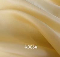 A close-up of smooth, light yellow Longan Craft Colorful Satin Viscose Fabric with gentle folds and a soft sheen. The text "K006#" appears at the bottom center of the image. Ideal for formal dresses, this polyester viscose twill is sold by the yard.