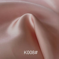 A close-up of Longan Craft’s Colorful Satin Viscose Fabric By The Yard, showcasing its smooth, light pink twill weave with gentle folds. The code K008# is featured at the bottom center of the image.
