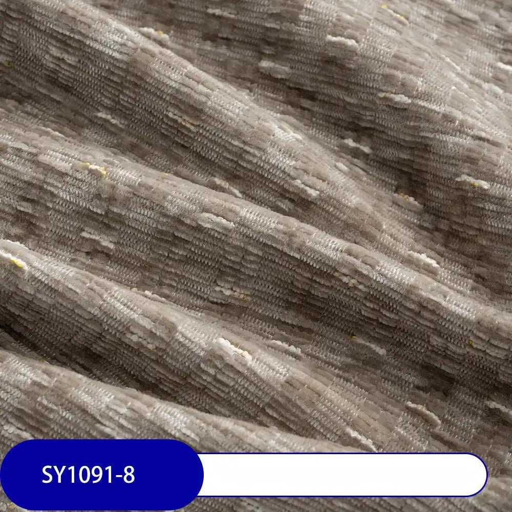 A close-up of Longan Craft’s Colorful Slub Chenille Fabric shows its light brown slubby texture with horizontal ridges and subtle sheen. The label at the bottom left reads "SY1091-8". Ideal for home decor, available by the yard.