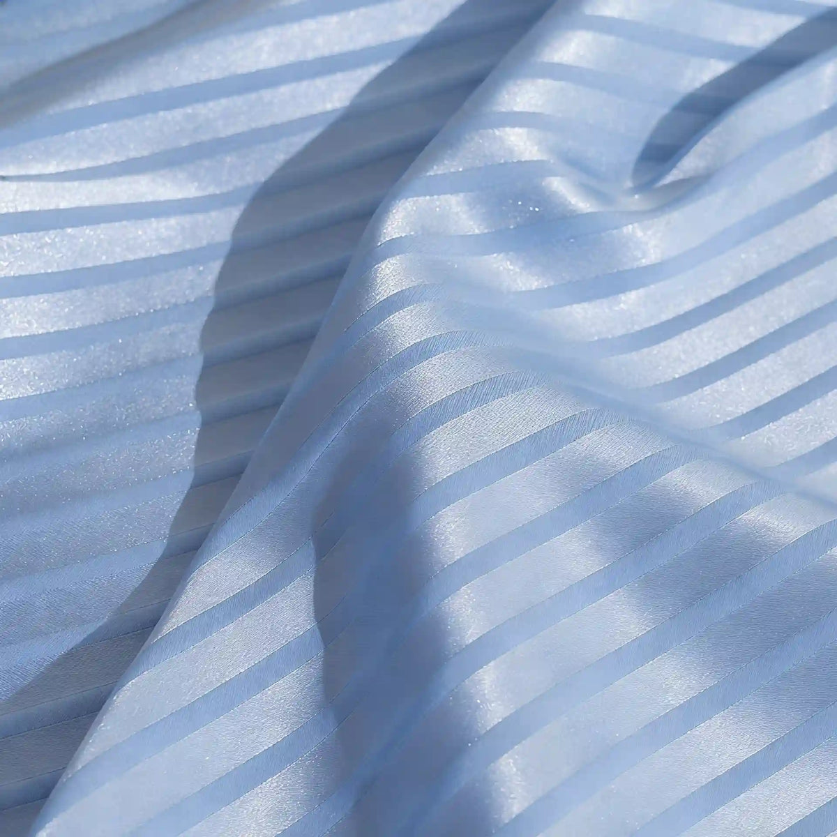 Close-up of Longan Craft’s Colorful Striped Jacquard Satin Fabric By The Yard—shiny polyester material with alternating glossy and matte stripes, softly draped to show its smooth, breathable texture for dressmaking.
