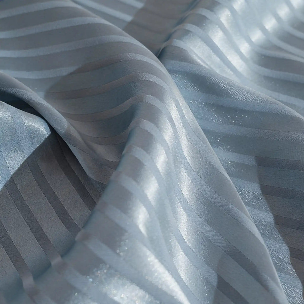 A close-up of Longan Craft's Colorful Striped Jacquard Satin Fabric by the yard, featuring shiny polyester stripes in alternating matte and glossy finishes, smoothly draped to reveal its soft, breathable quality for dressmaking.
