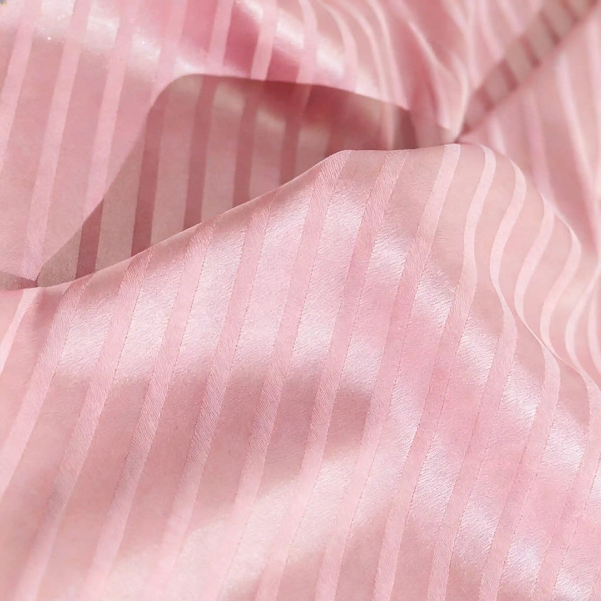 Close-up of Longan Craft’s Colorful Striped Jacquard Satin Fabric by the yard, featuring shiny pink vertical stripes and gentle folds—smooth, breathable polyester ideal for dressmaking.