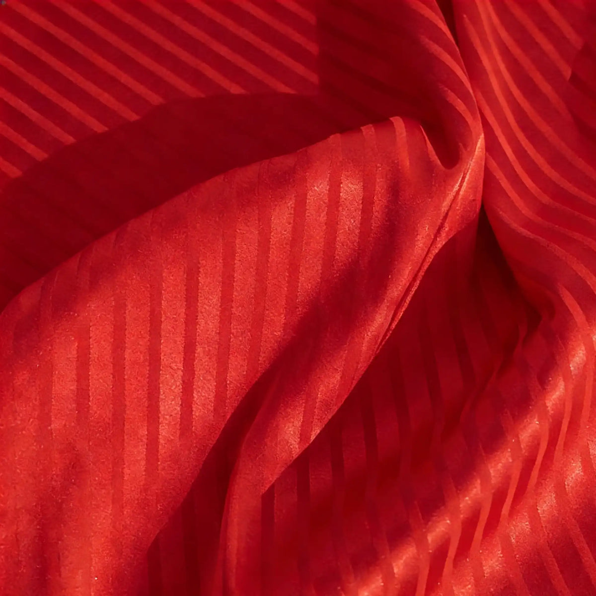 Close-up of Longan Craft’s Colorful Striped Jacquard Satin Fabric by the yard—shiny polyester with alternating wide and narrow diagonal stripes, softly draped for elegant folds; ideal smooth, breathable material for dressmaking.