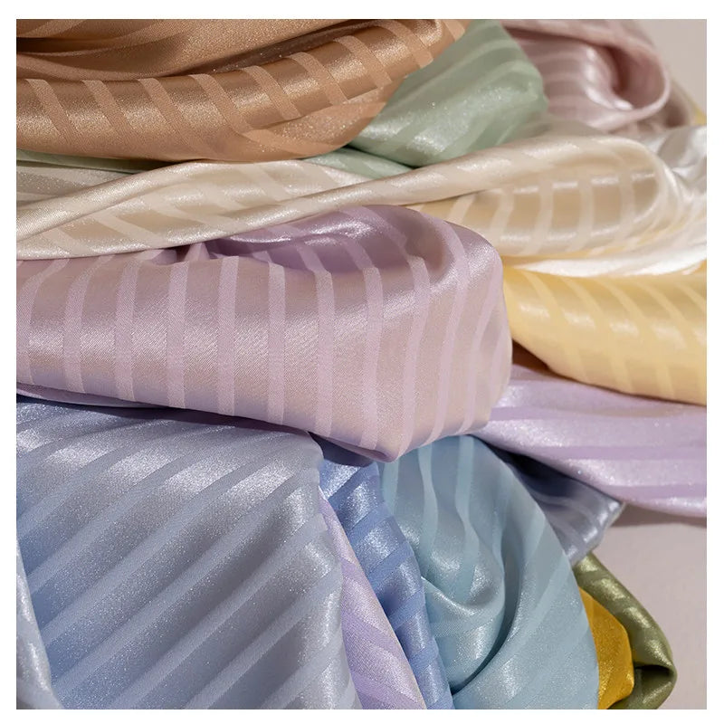 A close-up of Longan Craft’s Colorful Striped Jacquard Satin Fabric by the yard, a shiny, smooth polyester satin in pastel pink, lavender, blue, yellow, green, cream, and tan stripes—perfect for elegant dressmaking.