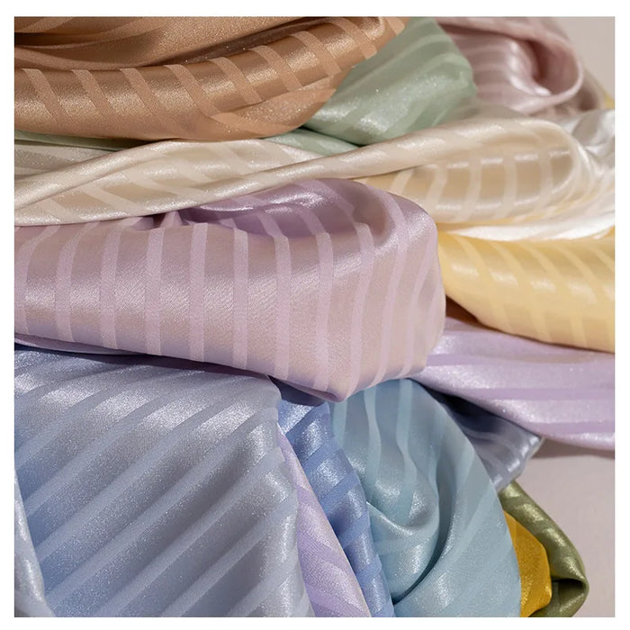 A close-up of Longan Craft’s Colorful Striped Jacquard Satin Fabric by the yard, a shiny, smooth polyester satin in pastel pink, lavender, blue, yellow, green, cream, and tan stripes—perfect for elegant dressmaking.