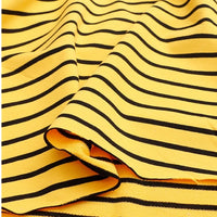 A close-up of Longan Craft’s Colorful Striped Stretch French Terry Fabric, a knit cotton-spandex material with evenly spaced black stripes and gentle folds, ideal for sweatshirts and available by the yard.